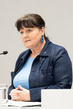 Bildbeschreibung: Eine Frau steht an einem Rednerpult und spricht.