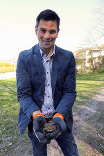 Eine Person stehend mit einer Kröte in den Händen.