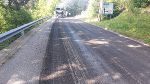 Bildbeschreibung: Fahrbahn mit Straßenbelag. Im Hintergrund ein LKW und grüne Vegetation.