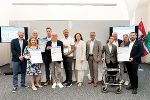 Landesrätin Claudia Holzer, VCÖ-Experte Michael Schwendinger und Peter Wallis, Regionalmanager der ÖBB-Personenverkehr AG, überreichten die VCÖ-Mobilitätspreise Steiermark 2026 an die glücklichen Gewinnerinnen und Gewinner. © Land Steiermark/Melanie Laimer; Verwendung bei Quellenangabe honorarfrei
