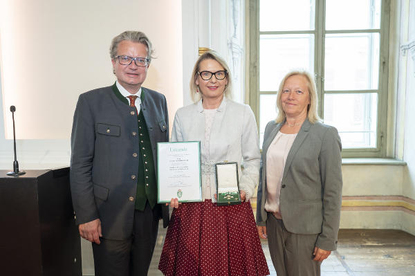 Die Schriftstellerin Claudia Rossbacher (M.) mit Landeshauptmann Christopher Drexler (l.) und der Nationalratsabgeordneten Verena Nussbaum (r.) bei der Überreichung des Goldenen Ehrenzeichens des Landes Steiermark. © Land Steiermark/Foto Fischer; bei Quellenangabe honorarfrei