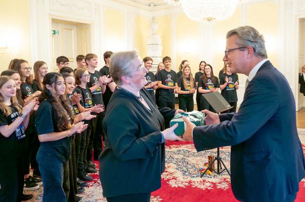 Landeshauptmann Christopher Drexler und Chorleiterin Maria Fürntratt mit dem „hib.art.chor″ beim Empfang im Weißen Saal der Grazer Burg. © Land Steiermark; bei Quellenangabe honorarfrei