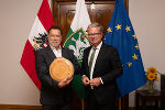 Landeshauptmann Christopher Drexler überreichte Arnold Schwarzenegger einen Laib Arzberger Stollenkäse © Land Steiermark / Michaela Lorber Landeshauptmann Christopher Drexler überreichte Arnold Schwarzenegger einen Laib Arzberger Stollenkäse