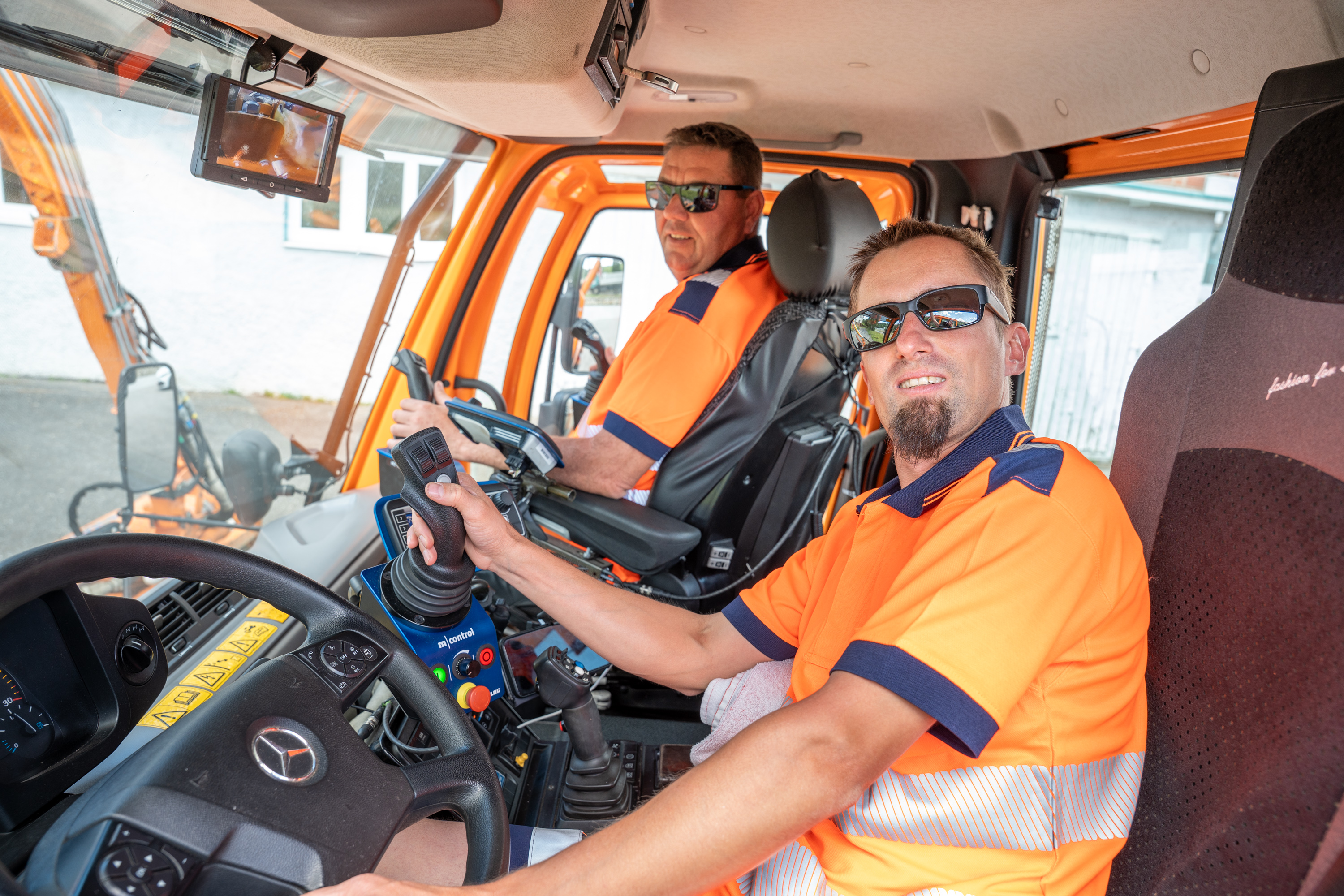 Perfektes Zusammenspiel ist notwendig, wenn das Duo des Straßenerhaltungsdienstes seinen Mercedes-Lkw steuert und parallel die Mähwerke bedienen muss.